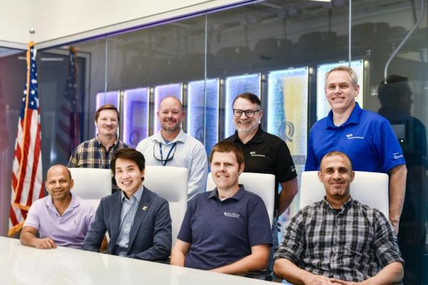 Team of four people seated in front of four people standing in the network operations center at EPB at Chattanooga.