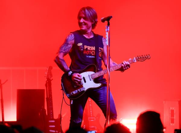 Keith Urban playing guitar on stage during a surprise pop-up show in downtown Nashville, Tennessee, celebrating his new album 'HIGH'